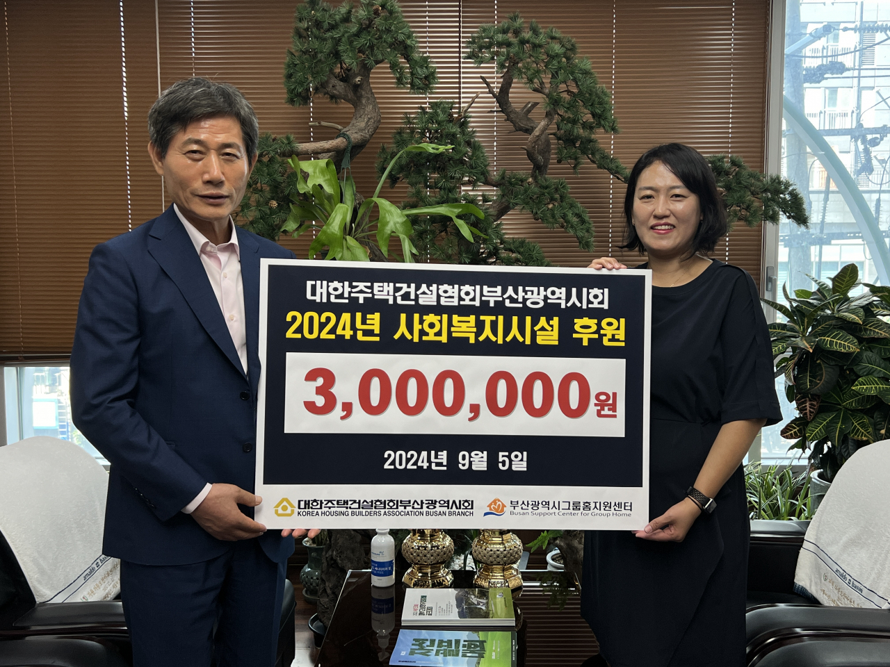 박재복 대한주택건설협회 부산시회장(사진 왼쪽)이 5일 부산시 그룹홈지원센터에 후원금을 전달하고 기념촬영하고 있다. [사진=주택건설협회 부산시회]