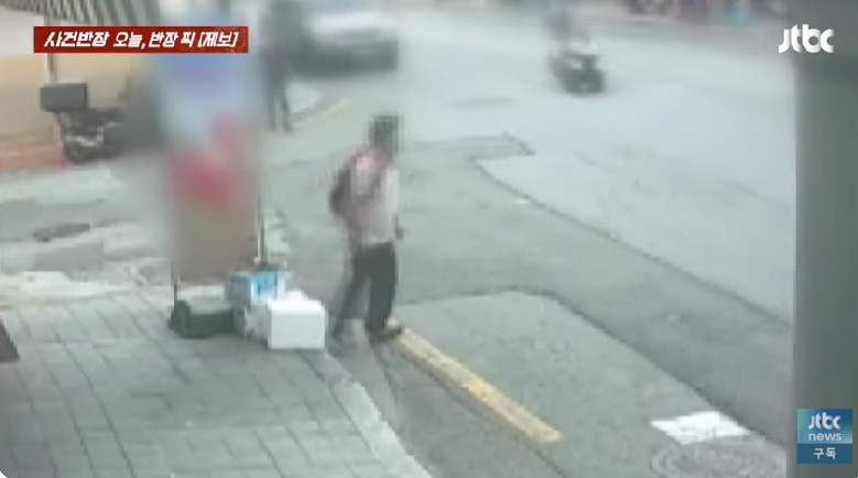 한 남성이 입간판 옆에 짐을 두고 자리를 뜨고 있다. 스티로폼 박스 안에는 음식물 쓰레기가 담겨 있었다고 한다. [jtbc '사건반장' 갈무리]