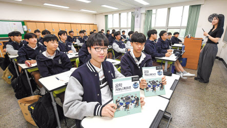 서울 선덕고 학생들이 ‘공학 커뮤니케이션’수업 중 교과서를 들어보이고 있다.