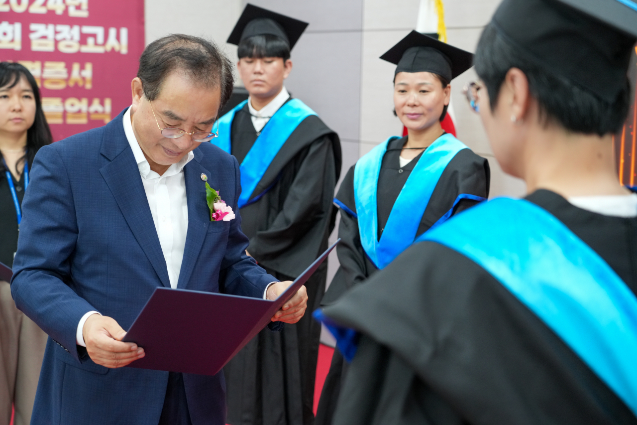 하윤수 부산시교육감(왼쪽)이 9일 오후 부산시교육청 별관 국제회의실에서 열린 ‘2024년도 제2회 검정고시 합격증서 수여식’에서 합격생에게 검정고시 합격증서를 수여하고 있다. [사진=부산교육청]