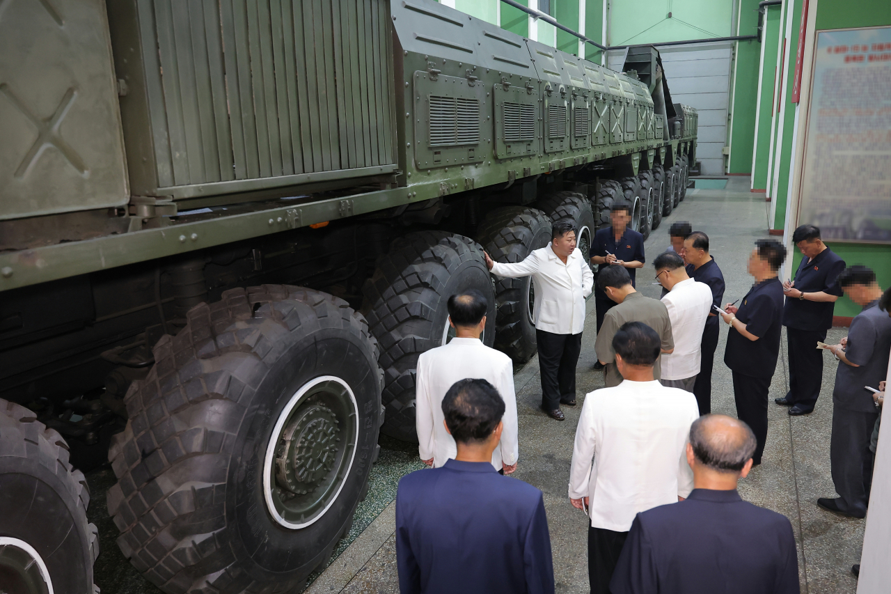 북한이 12축 24륜의 이동식발사대(TEL)를 처음 공개하며 새로운 대륙간탄도미사일(ICBM) 개발 가능성을 시사한 가운데 전시용에 불과하다는 관측이 나온다. 김정은 국무위원장이 제2경제위원회 산하 국방공업기업소를 현지시찰하면서 TEL 바퀴에 손을 얹고 있다. [평양 노동신문=뉴스1]