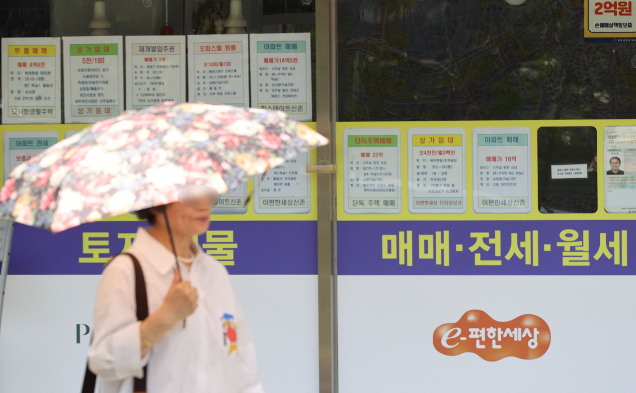 서울 한 부동산중개사무소 앞을 시민이 지나가고 있다.[연합]