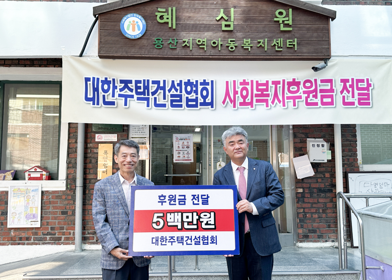 정원주 회장(사진 오른쪽)이 권필환 혜심원 원장에게 후원금을 전달했다[사진=대한주택건설협회 제공]