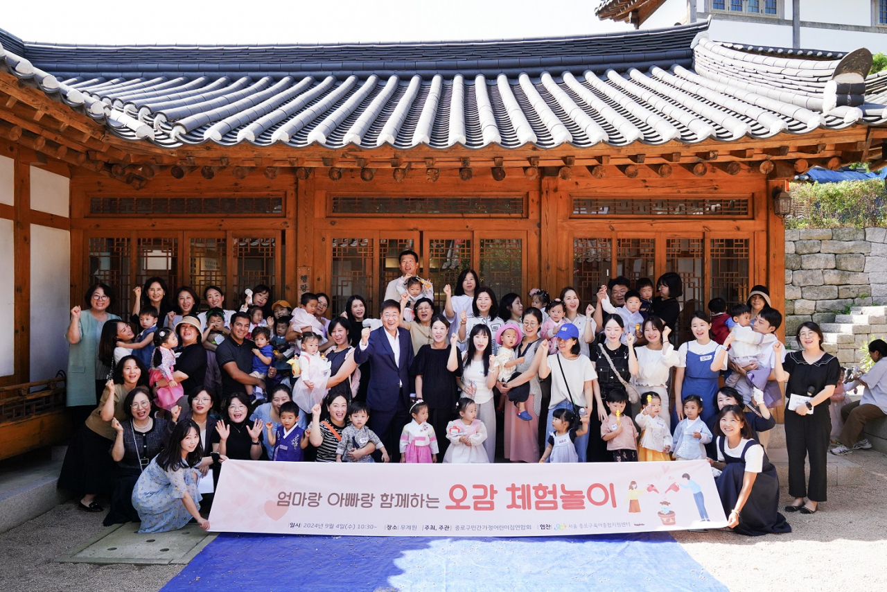 지난 4일 학부모 참여수업 ‘엄마랑 아빠랑 함께하는 오감 체험놀이’에서 정문헌 종로구청장이 참여한 어린이, 학부모들과 함께 기념촬영을 하고 있다. [종로구 제공]