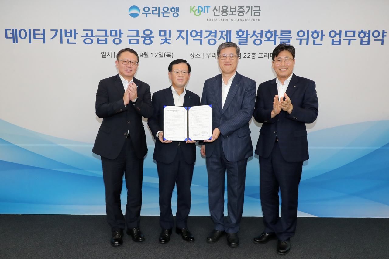 12일 우리은행 본점에서 열린 공급망금융 및 지역경제 활성화를 위한 업무협약식에 참석한 조병규(왼쪽 두 번째) 우리은행장, 최원목(오른쪽 두 번째) 신용보증기금 이사장, 정진완(왼쪽 첫 번째) 우리은행 중소기업그룹장, 정현호(오른쪽 첫 번째) 신용보증기금 신용보증부 본부장이 기념 촬영을 하고 있다.[우리은행 제공]