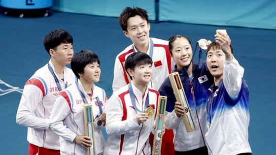 2024 파리올림픽 탁구 혼합복식 동메달을 목에 건 한국의 임종훈(오른쪽부터)과 신유빈이 7월 31일(한국시간) 시상식이 끝난 뒤 금메달을 딴 중국의 왕추친-쑨잉사 조, 은메달리스트인 북한의 김금영-리정식 조와 삼성 Z 플립6로 기념촬영을 하고 있다. [뉴시스]