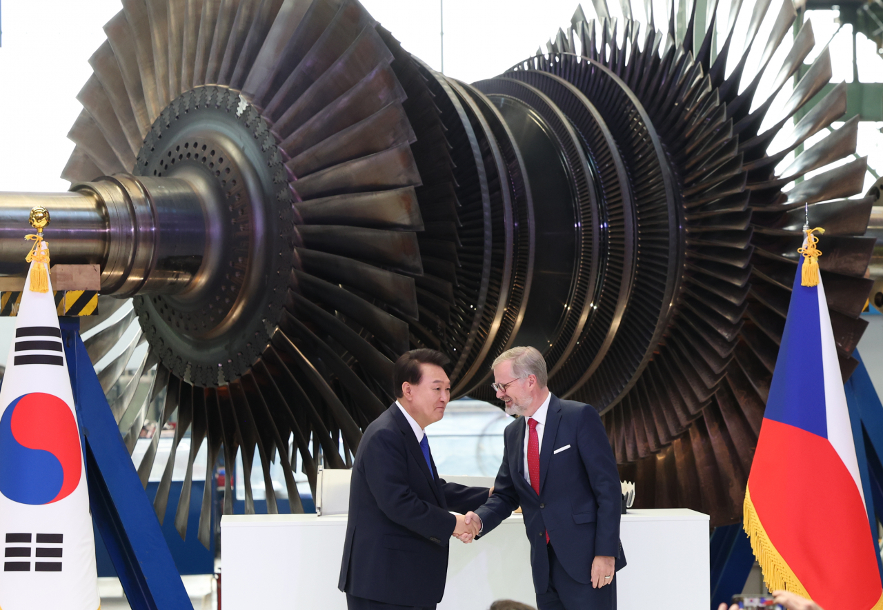 President Yoon Suk Yeol (left) and Czech Prime Minister Petr Fiala shake hands during Yoon's visit to Doosan Skoda Power headquarters in Plzen, Czech Republic, Friday. (Yonhap)
