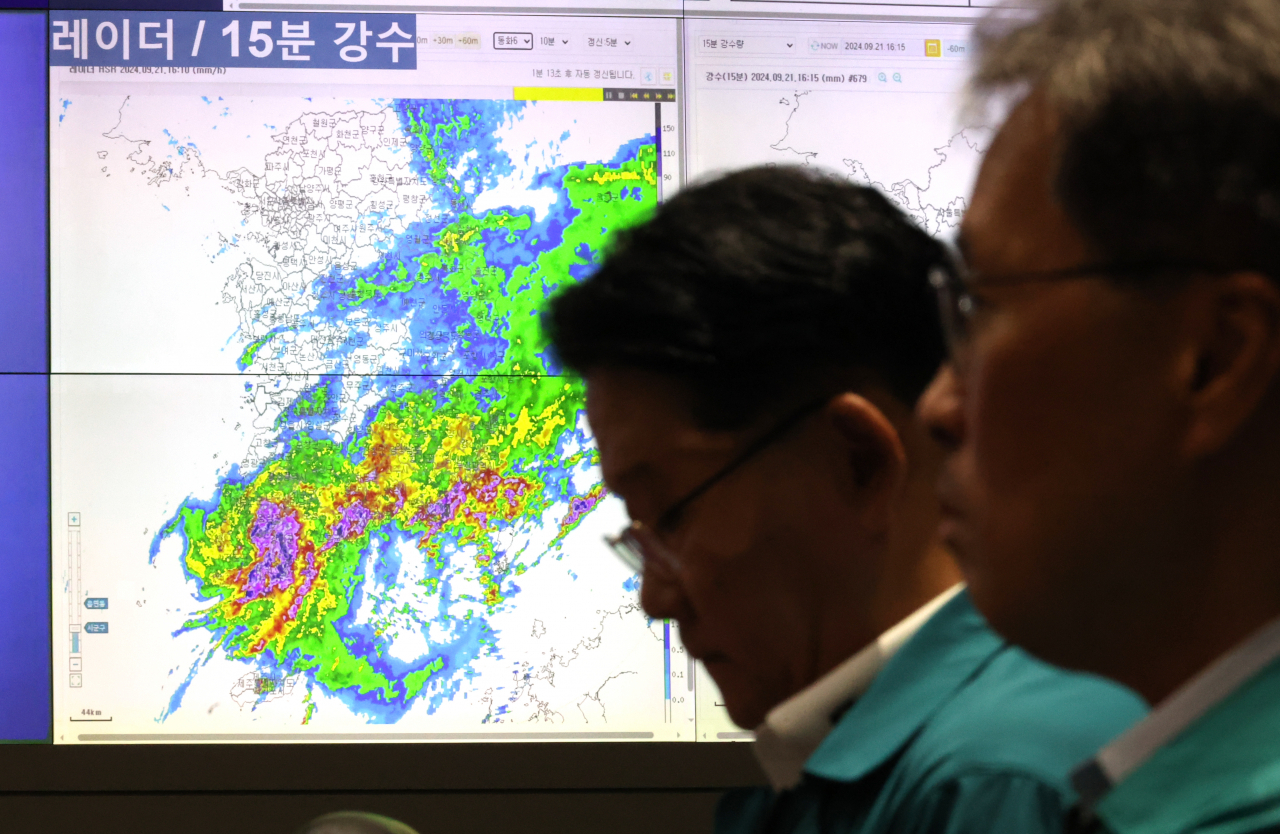 한덕수 국무총리 주재로 21일 서울 종로구 정부서울청사 상황실에서 열린 호우대처 상황 점검회의에서 참석자들이 자료를 살펴보고 있다. [연합]