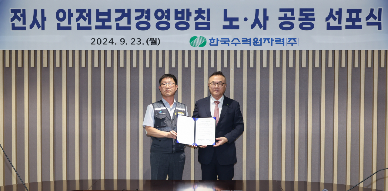 황주호(오른쪽) 한국수력원자력 사장이 23일 경북 경주 본사에서 열린 '안전보건 경영방침 노사 공동 선포식'에서 기념촬영을 하고 있다. [한국수력원자력 제공]