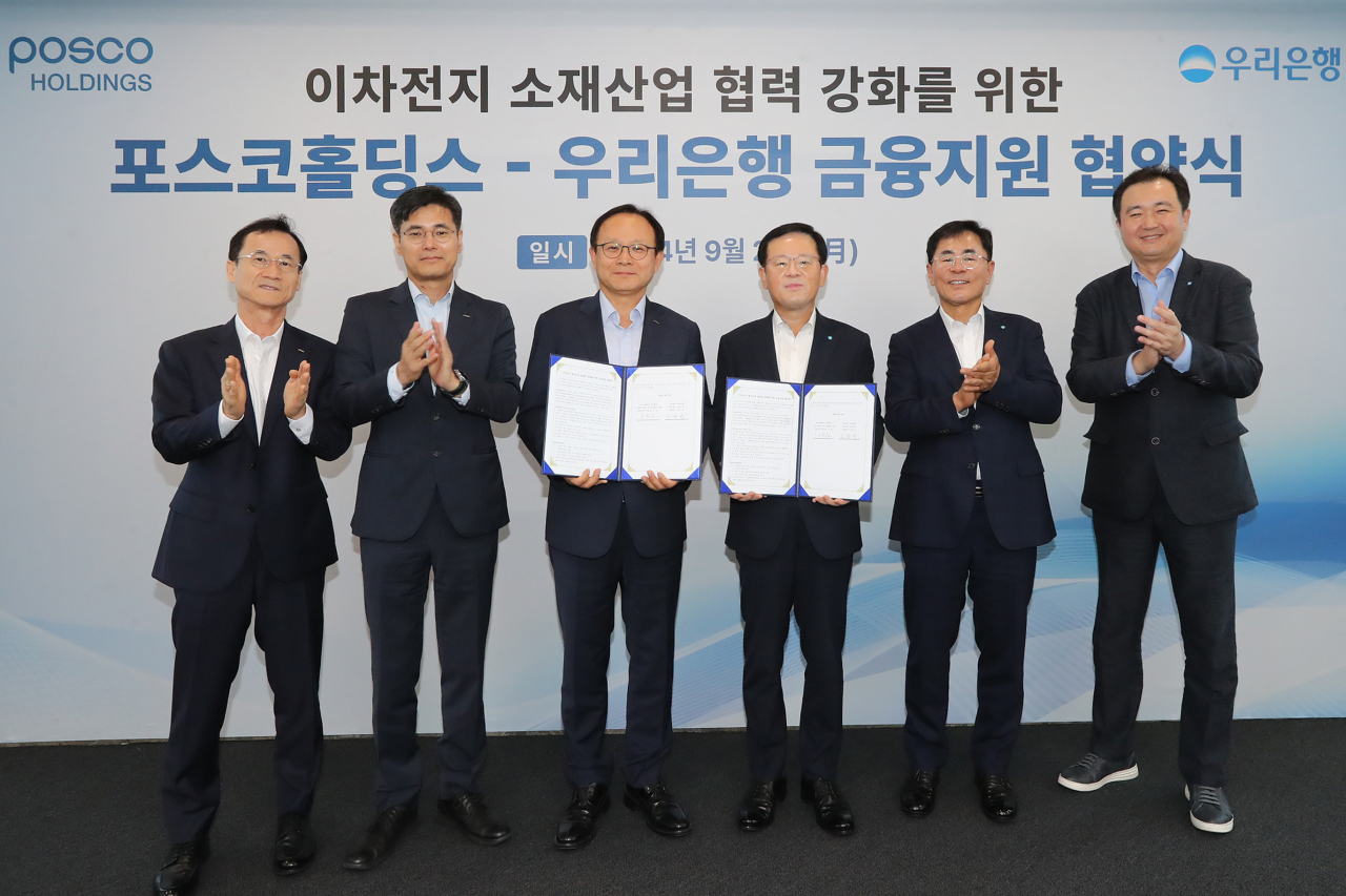 23일 우리은행 본점에서 포스코홀딩스㈜와 진행한 ‘이차전지 핵심소재 경쟁력 강화를 위한 금융지원 업무협약’ 체결식에서 조병규(오른쪽 세 번째) 우리은행장과 정기섭(왼쪽 세 번째) 포스코홀딩스 사장 등이 기념촬영을 하고 있다. [우리은행 제공]