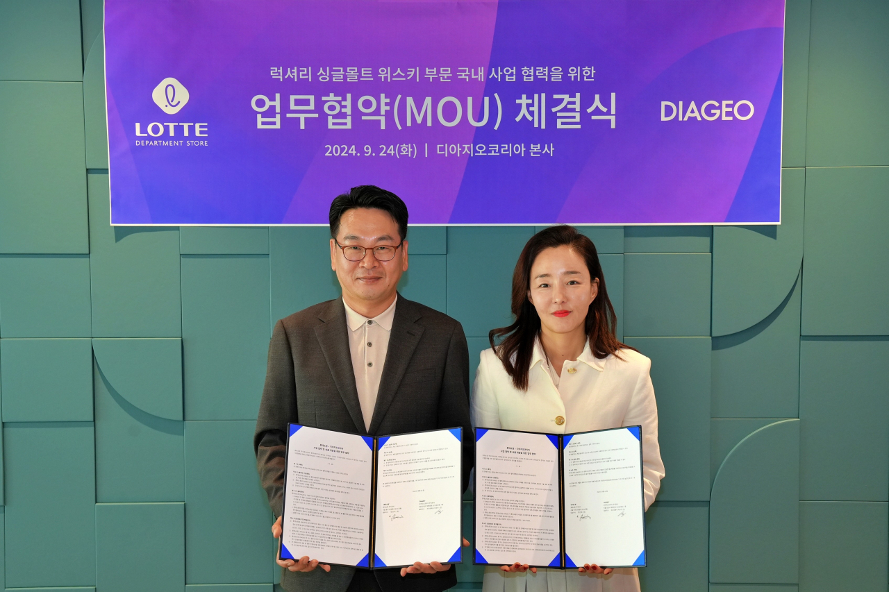 윤우욱(왼쪽) 롯데백화점 푸드 부문장과 신혜정 디아지오코리아 럭셔리 세일즈 및 대외협력 상무가 업무협약 체결식에서 기념 사진을 촬영하고 있다. [롯데백화점 제공]