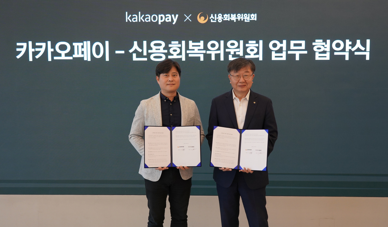 신원근(왼쪽) 카카오페이 대표와 이재연 신용회복위원회 위원장(오른쪽)이 24일 경기도 판교 카카오페이 오피스에서 제휴 협약식을 진행한 뒤 기념촬영을 진행하고 있다. [카카오페이 제공]