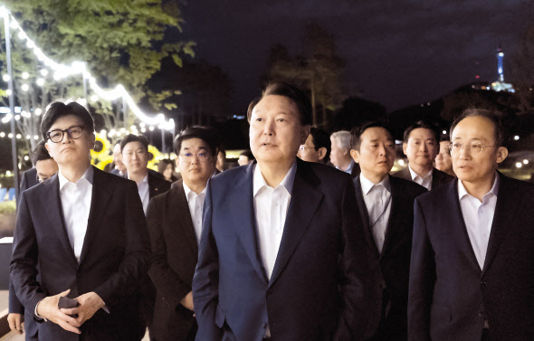 윤석열 대통령이 24일 서울 용산 대통령실 앞 분수정원에서 열린 국민의힘 지도부 초청 만찬 뒤 한동훈(왼쪽) 대표, 추경호(오른쪽) 원내대표 등 국민의힘 지도부, 대통령실 참모진과 함께 산책을 하고 있다. [연합]