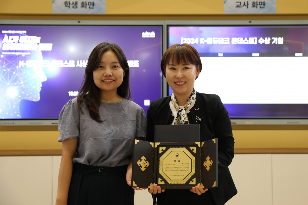 원자희 웅진씽크빅 AI 디지털교과서개발실장(오른쪽)과 황예슬 교육부 사무관이 2024 K-에듀테크 콘테스트 시상식 이후 기념촬영을 하고 있다. [웅진씽크빅 제공]