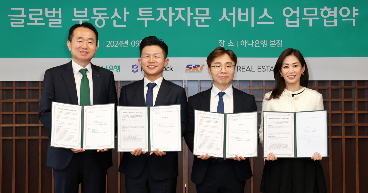 하나은행은 글로벌 부동산 투자에 관심이 있는 손님들을 대상으로 최적의 해외 부동산 투자 솔루션을 제안하는 ‘글로벌 부동산 투자자문 서비스’를 시행한다고 26일 밝혔다. 사진은 24일 서울 을지로 하나은행 본사에서 서비스 제공을 위한 해외 유명 부동산 플랫폼 기업들과의 업무협약식에서 김영훈(맨 왼쪽) 하나은행 자산관리그룹장이 조민수(왼쪽 두 번째) JOO REAL ESTATE 대표이사, 이지웅(오른쪽 두 번째) 빌드블록 부대표, 펄리 탄 SRI 디스트릭트 디렉터와 기념촬영을 하는 모습. [하나은행 제공]