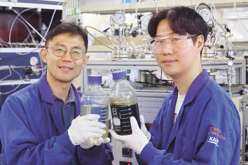 KAIST 생명화학공학과의 최민기(왼쪽) 교수와 석진 박사과정생이 개발한 촉매를 들어보이고 있다. [KAIST 제공]