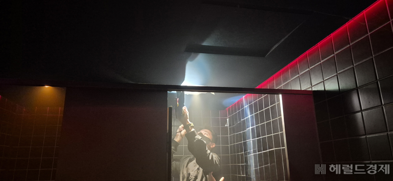 경찰이 강남구 강남대로의 한 클럽 화장실에서 마약이 숨겨져 있는지 살펴보고 있다. 김용재 기자