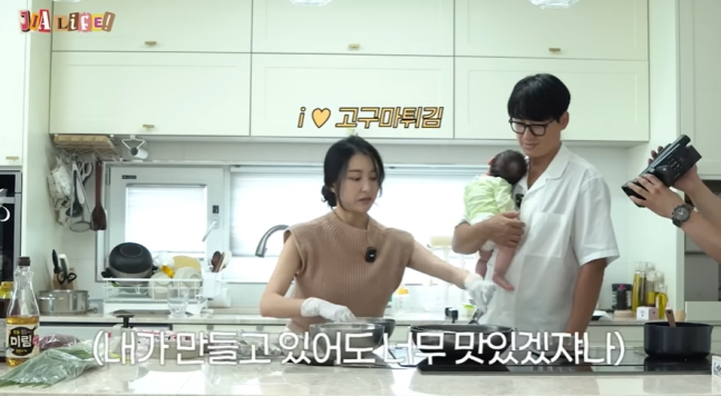 가수 겸 배우 이지훈과 아내 미우라 아야네가 생후 3개월 된 딸을 안고 튀김 요리를 하는 모습. [유튜브 채널 ‘지아라이프’ 캡처]