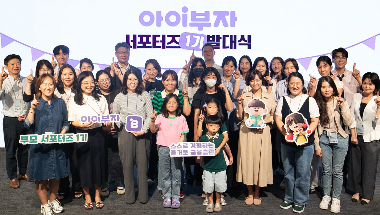 하나은행은 27일 서울시 중구 을지로 소재 하나은행 본점에서 알파세대를 위한 체험형 금융 플랫폼 '아이부자'의 서포터즈 발대식을 개최했다. 이날 발대식에 참석한 '아이부자' 서포터즈와 하나은행 임직원들이 기념 촬영을 하고 있다. [하나은행 제공]