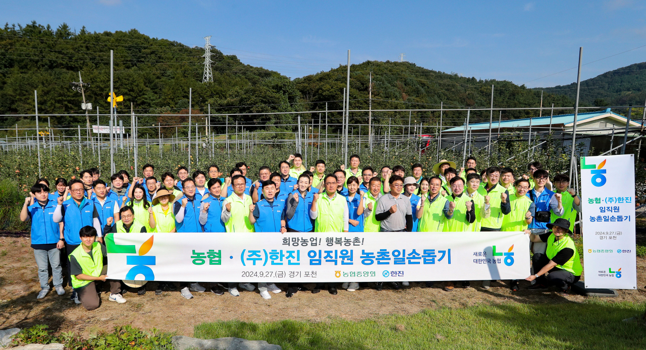 지난 27일 경기 포천시 소재 사과농가에서 일손돕기에 나선 한진과 농협 양사 임직원들이 기념 촬영을 하고 있다. [한진 제공]