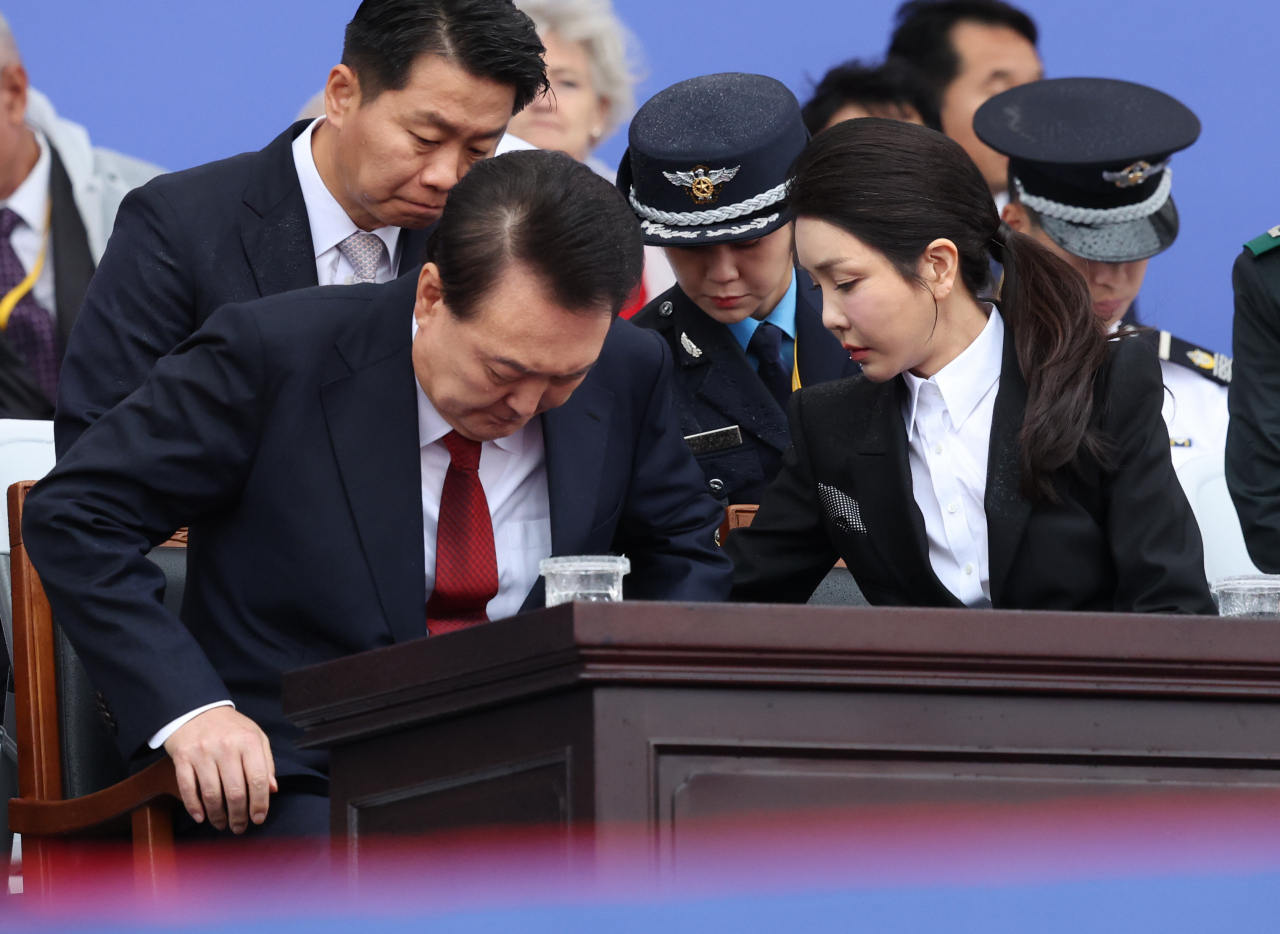 윤석열 대통령의 부인 김건희 여사가 1일 성남 서울공항에서 열린 건군 76주년 국군의날 기념식에서 윤 대통령 의자의 빗물을 닦아 주고 있다. [연합]