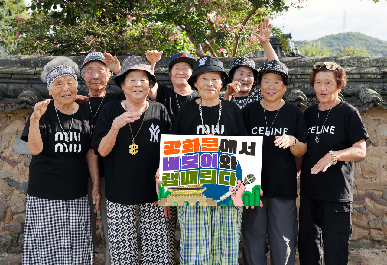 수니와칠공주는 광화문 공연을 알리는 손 푯말을 들고 기념 촬영을 하고 있다.[칠곡군 제공]