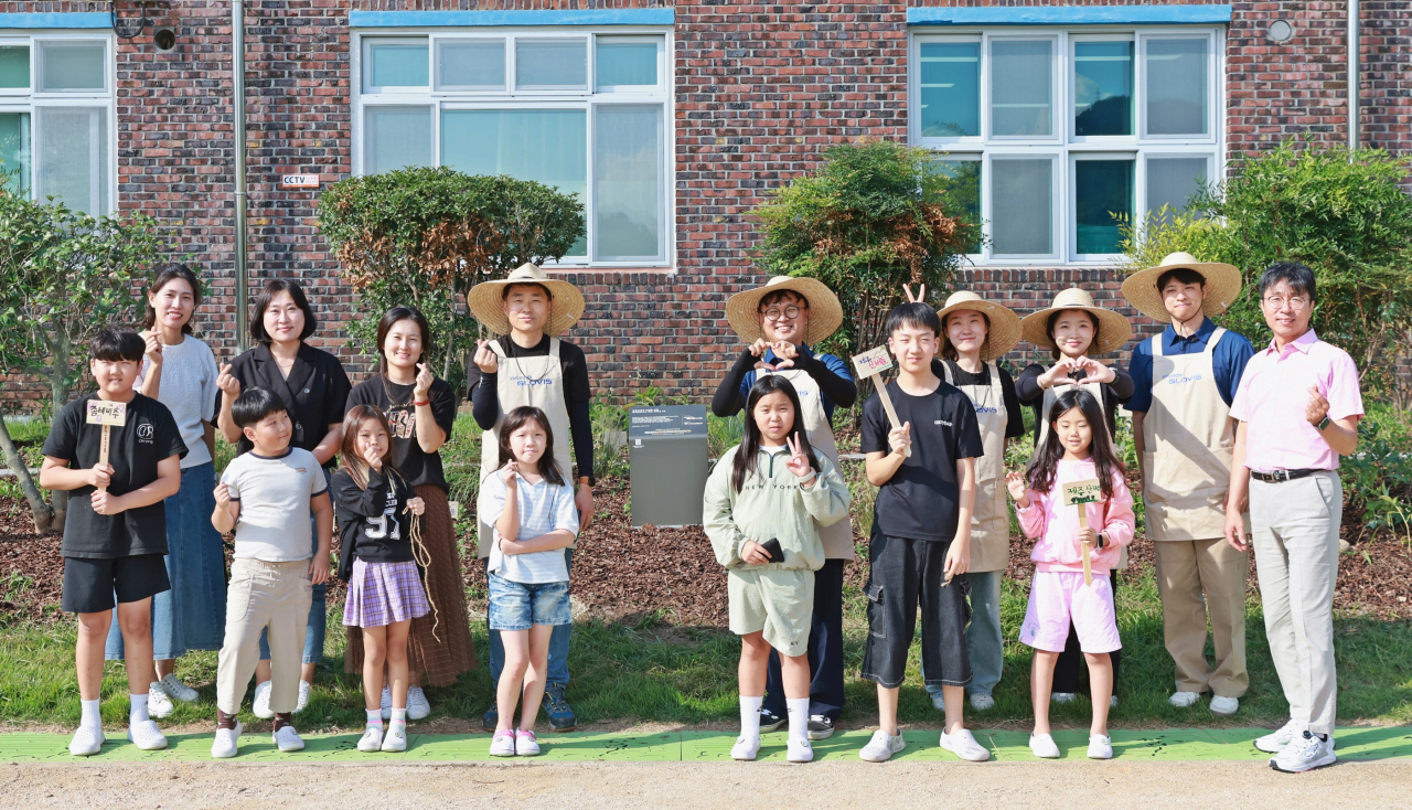 현대글로비스 임직원 봉사단이 지난달 30일 광양 옥룡초등학교에 생태숲을 조성하고 학생들과 기념촬영을 하고 있다. [현대글로비스 제공]