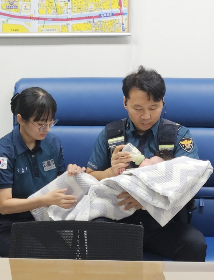 서울 관수파출소에 근무하는 안정수 경장이 신생아를 돌보고 있다. [서울 관수파출소 제공]