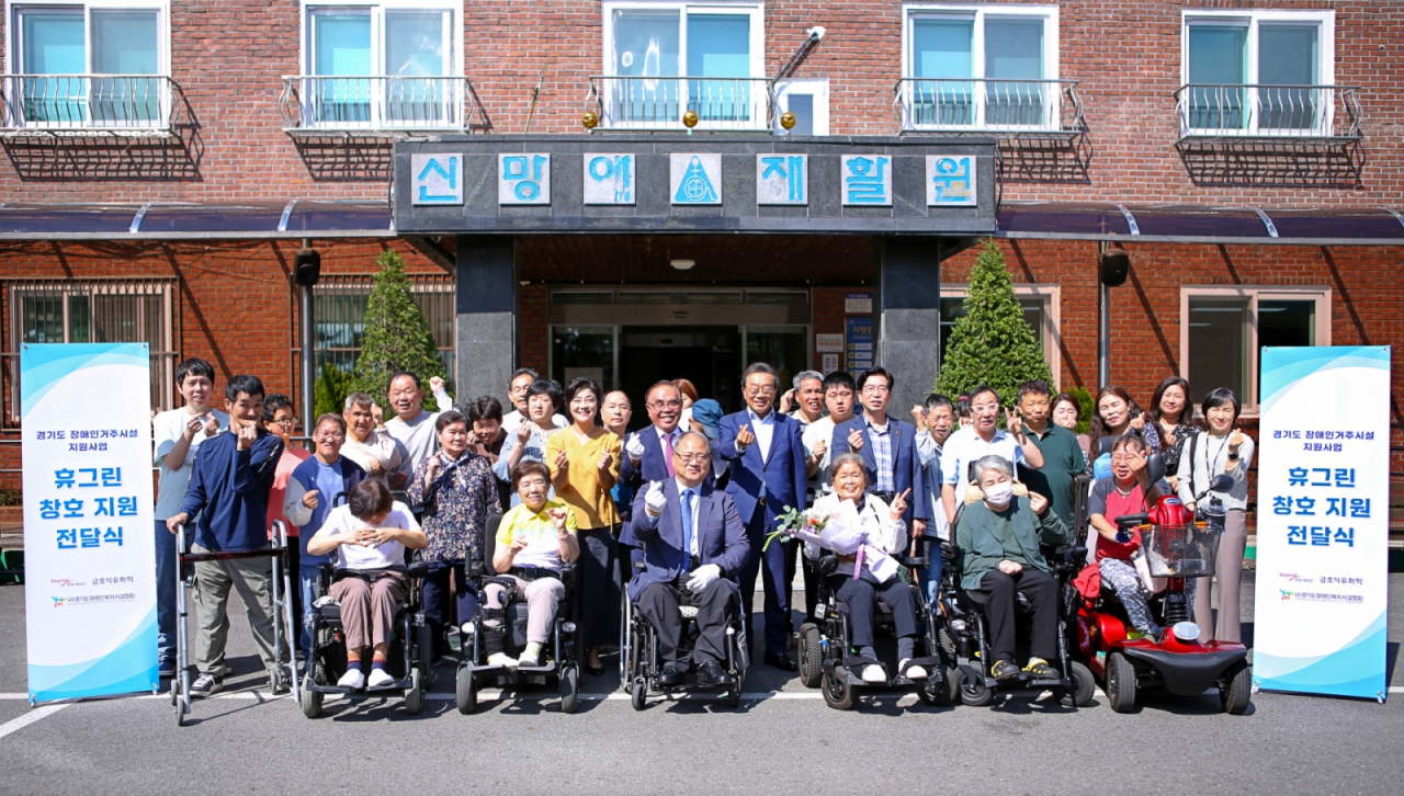 김광식(앞줄 왼쪽 세번째) 경기도장애인복지시설협회장, 조주현(뒷줄 왼쪽 네번째부터) 신망애재활원장, 김양원 신망애복지재단 대표, 백종훈 금호석유화학 대표, 최재웅 남양주시 복지국 국장이 2일 경기도 남양주 소재 신망애재활원에서 열린 창호교체 지원사업 기념식에서 시설 거주인들과 기념촬영을 하고 있다. [금호석유화학 제공]