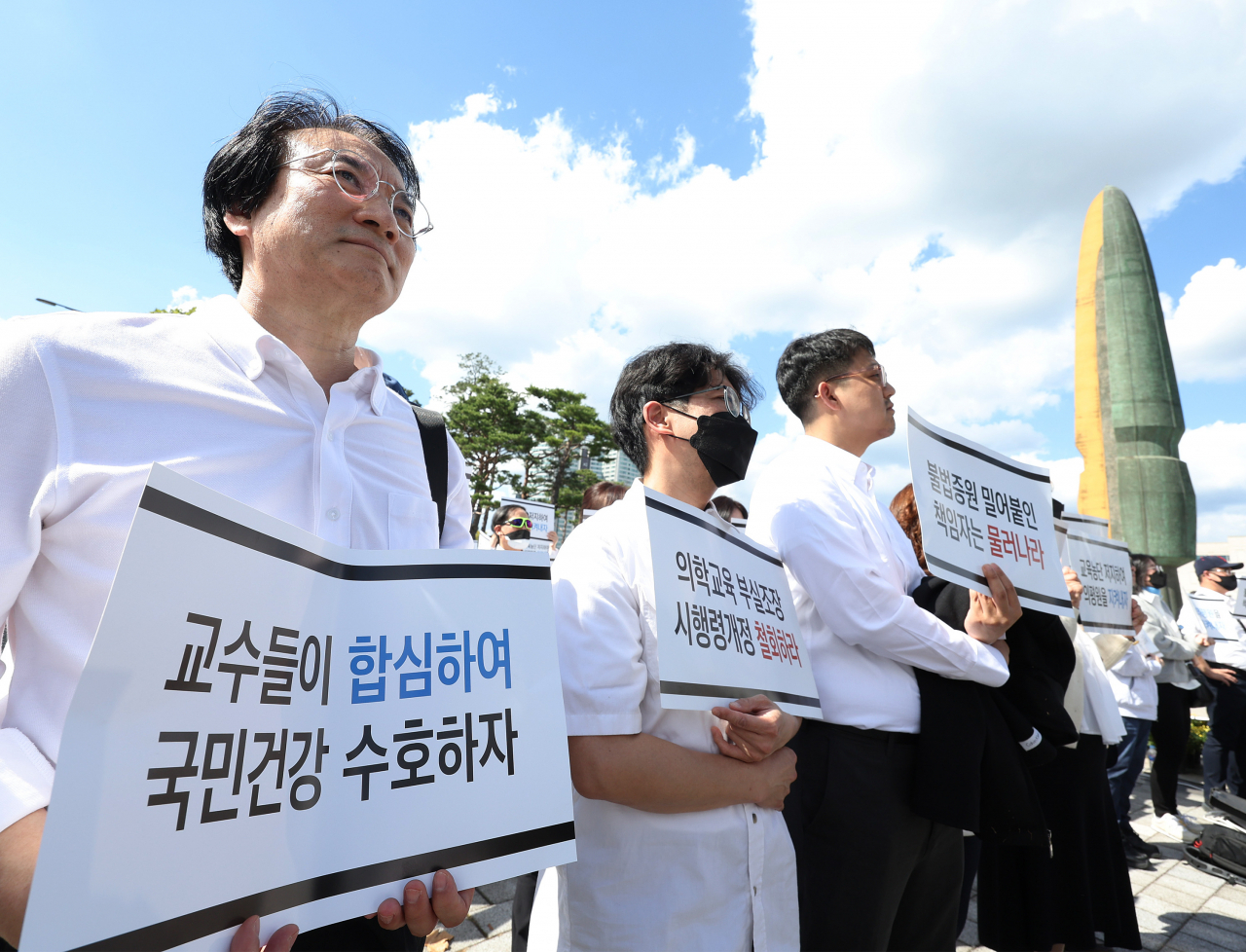의대교수들이 3일 오후 서울 용산구 대통령실 인근에서 열린 한국의학교육평가원 무력화 저지 결의대회에서 손팻말을 들고 구호를 외치고 있다. [연합]