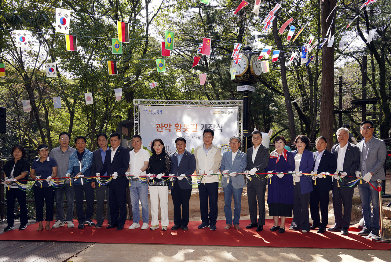 지난 9월 30일 서울 관악산 신림계곡 산책로에서 열린 ‘깨비증권 그린로드’ 개장식에서 강진두(오른쪽에서 여섯 번째) KB증권 경영지원부문장 강진두 부사장과 박준희(오른쪽에서 여덟번째) 관악구청장, 박동창(오른쪽에서 일곱번째) 맨발걷기국민운동본부 회장 등 관계자들이 테이프 커팅식을 진행하며 기념 사진을 촬영하고 있다. [KB증권]