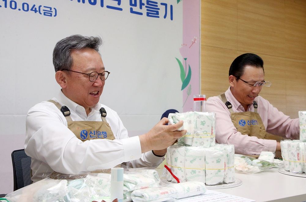 4일 서울시 중구 소재 신한은행 본점에서 진행된 ‘탄생을 축하해’ 임직원 봉사활동에서 정상혁(왼쪽) 신한은행장이 임직원들과 직접 기저귀 케이크를 제작하며 봉사활동에 참여하고 있는 모습. [신한은행 제공]