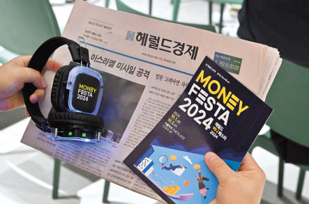헤럴드 머니 페스타 한 참석자가 팸플릿과 헤럴드경제 신문을 살펴보고 있다. 임세준 기자