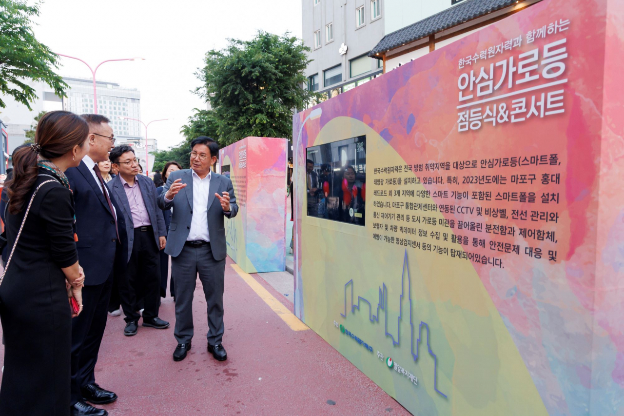 박강수 마포구청장(오른쪽)이 홍대 레드로드에 설치된 안심가로등을 설명하는 모습. [마포구 제공]