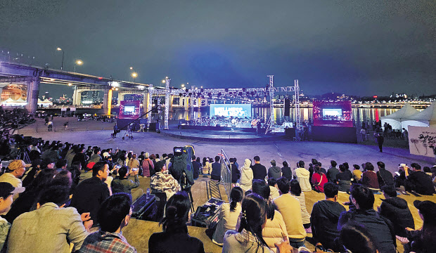 지난 6일 오후 서울 서초구 반포한강공원 달빛광장 수변무대에서 열린 ‘웰니스서울 2024’오프닝 행사를 지켜보는 시민들이 박수를 치고 있다(위쪽 사진). 오후 내내 차 없는 잠수교 뚜벅뚜벅 축제와 맞물려 열린 이번 행사에는 1만 명 이상의 시민들이 참가했으며, 대미를 장식한 ‘웰니스서울 음악회’에는 3500여 명의 관객이 참여해 깊어가는 가을밤을 즐겼다. 임세준·박해묵 기자