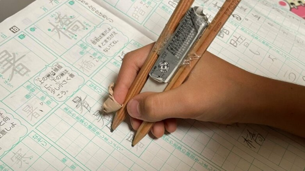 일본의 한 어린이가 한자 쓰기 숙제를 싫어한 나머지 숙제 양을 절반으로 줄일 수 있는 발명품을 만들어 화제다. 연필 2개를 서로 이어 붙인 이 발명품은 한 번에 위 아래 행간을 채울 수 있다. [FNN 갈무리]