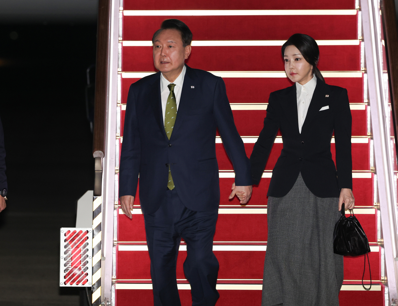 윤석열 대통령과 김건희 여사가 11일 성남 서울공항에서 필리핀, 싱가포르 국빈 방문 및 라오스 아세안 +3 회의를 마치고 귀국하며 전용기인 공군 1호기에서 내리고 있다. [연합]