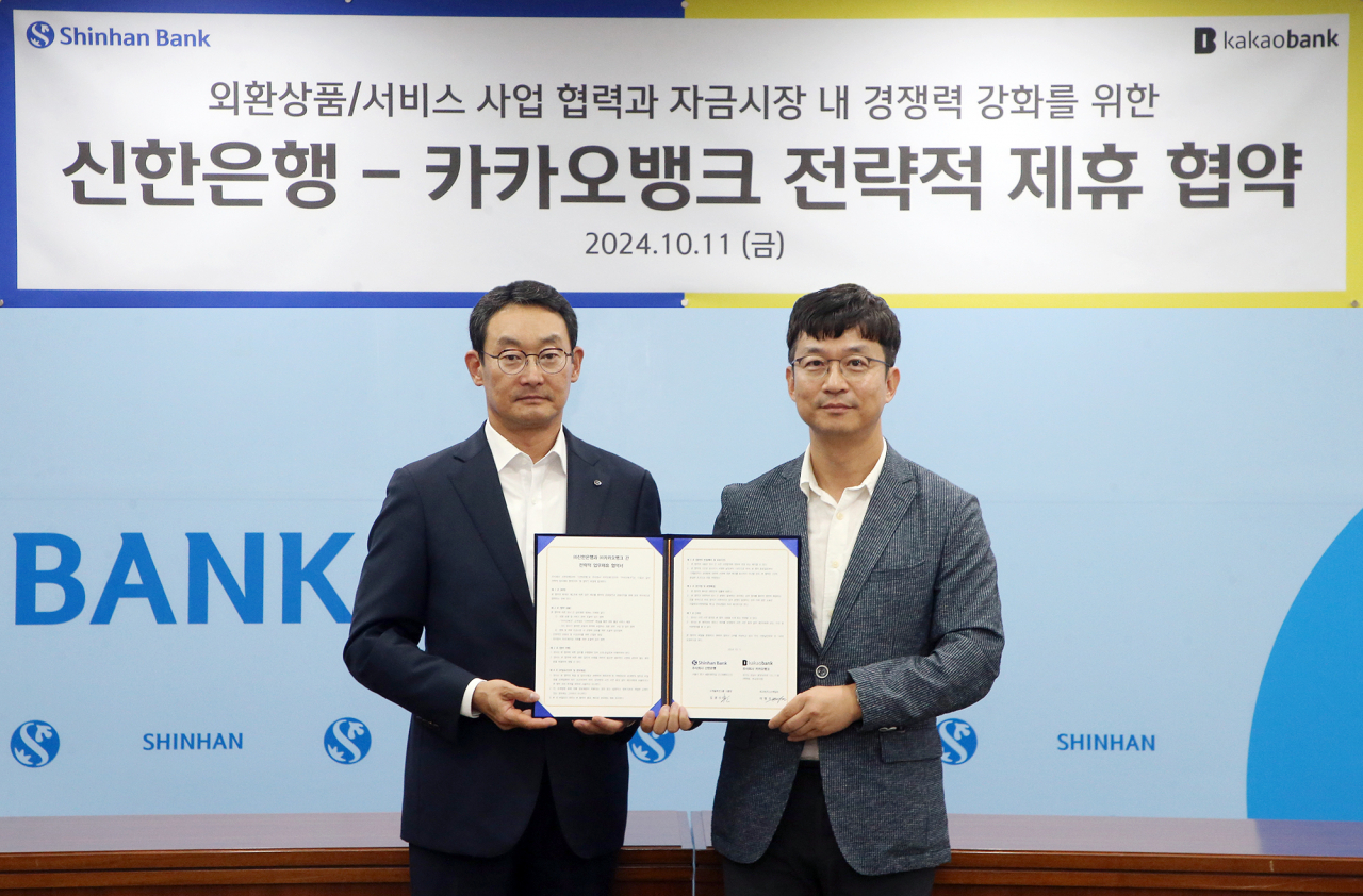 지난 11일 서울 중구 신한은행 본점에서 열린 업무협약식에서 이형주(오른쪽) 카카오뱅크 최고비즈니스책임자와 김광수(왼쪽) 신한은행 고객솔루션그룹장이 기념 촬영을 하고 있다.[카카오뱅크 제공]