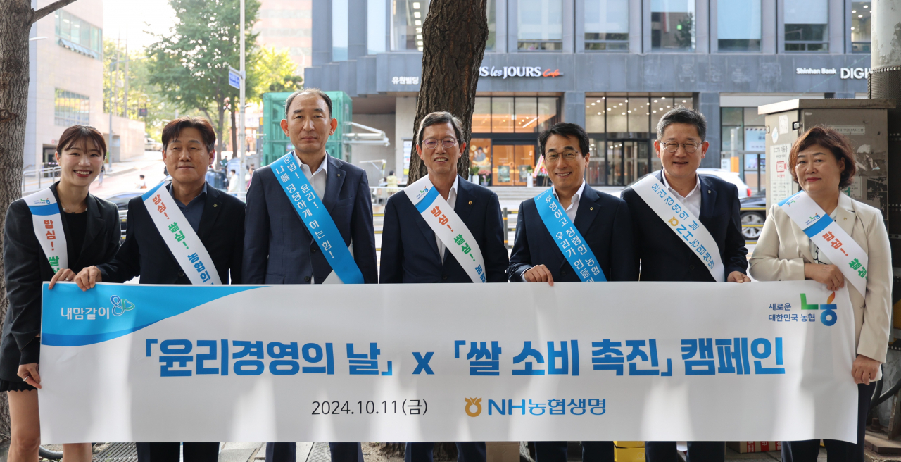 윤해진(왼쪽 네번째) NH농협생명 대표가 지난 11일 서울 시청역에서 윤리경영 및 쌀 소비 촉진 캠페인을 진행하며 기념사진을 촬영하고 있다. (사진제공=NH농협생명)