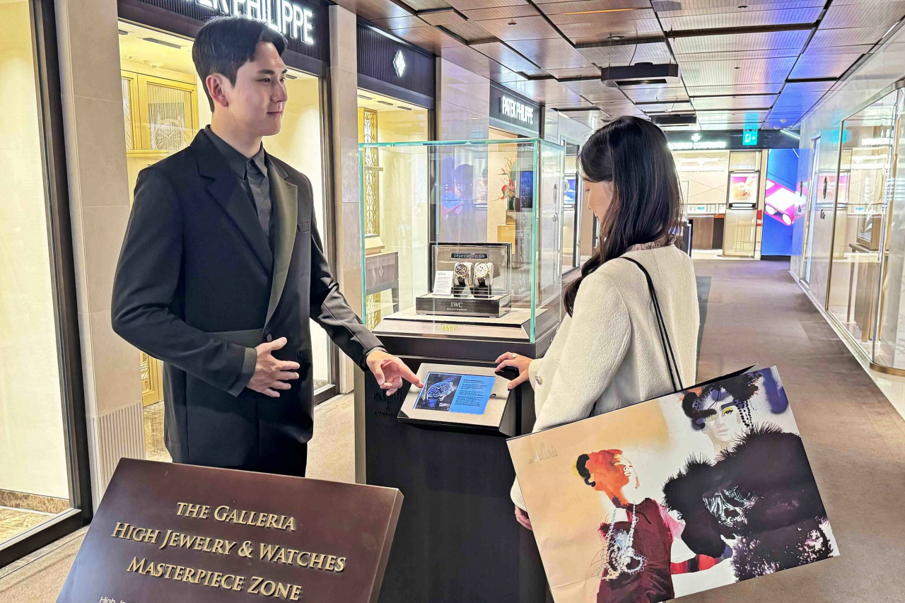 한화 갤러리아백화점 서울 명품관에서 새 유니폼을 입은 직원이 고객에게 안내하는 모습. [한화갤러리아 제공]