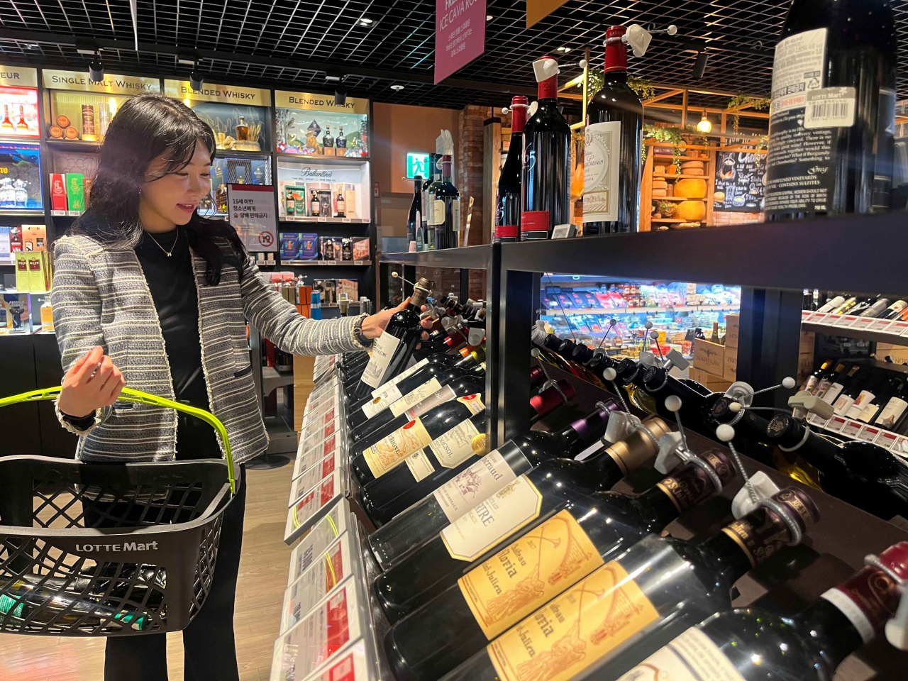 모델이 롯데마트 월드타워점 주류매장에서 와인을 보고 있다. [롯데쇼핑 제공]