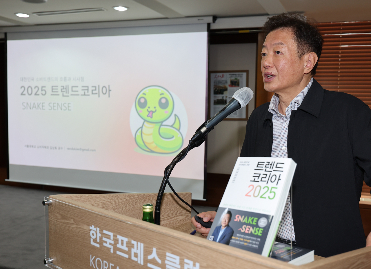 서울 중구 한국프레스센터에서 열린 '트렌드 코리아 2025' 출간 기자간담회에서 김난도 서울대 소비자학과 교수가 책을 소개하고 있다. [연합]