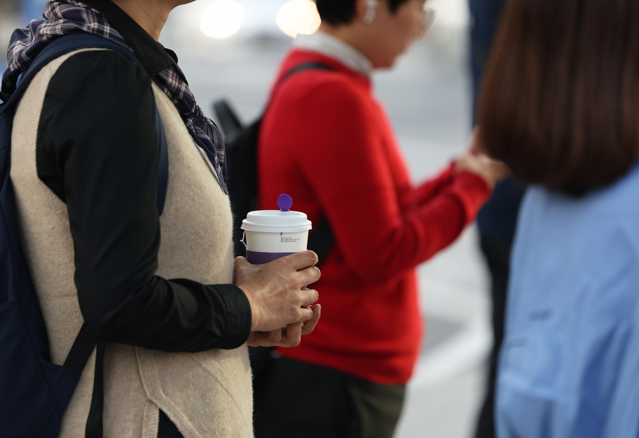 절기상 찬 이슬이 맺히기 시작한다는 한로인 8일 오전 서울 종로구 광화문광장 인근에서 한 시민이 음료를 들고 있다. [연합]