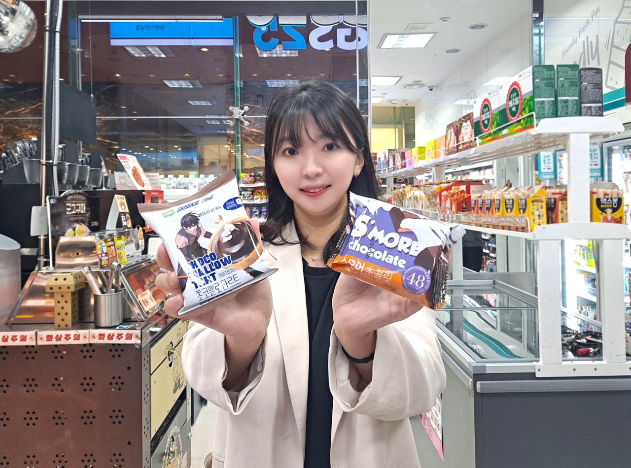 모델이 GS25에서 선보인 스모어 초콜릿과 가비지타임 초코멜로 타르트를 들고 포즈를 취하고 있다. [GS리테일 제공]