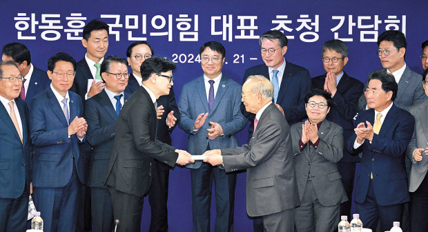 손경식(앞줄 오른쪽) 경총 회장이 21일 오전 서울 마포구 경총회관에서 열린 초청 간담회에서 한동훈(앞줄 왼쪽) 국민의힘 대표에게 정책건의서를 전달하고 있다. 임세준 기자