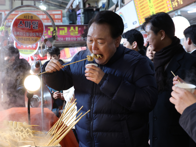 윤석열 대통령이 지난 1월 경기도 의정부시 의정부제일시장을 찾아 어묵을 먹고 있다. [연합]