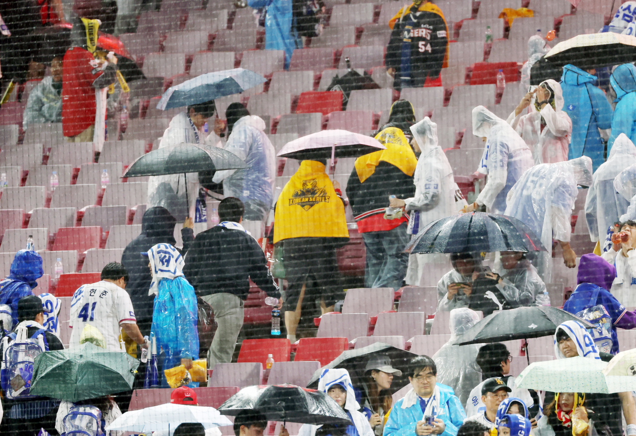 21일 광주 기아챔피언스필드에서 열린 2024 신한 SOL뱅크 KBO 포스트시즌 한국시리즈 1차전 삼성 라이온즈와 KIA 타이거즈의 경기가 우천 취소돼 관중들이 돌아가고 있다. 남은 경기는 22일 2차전에 앞서 6회초부터 진행된다. 연합뉴스