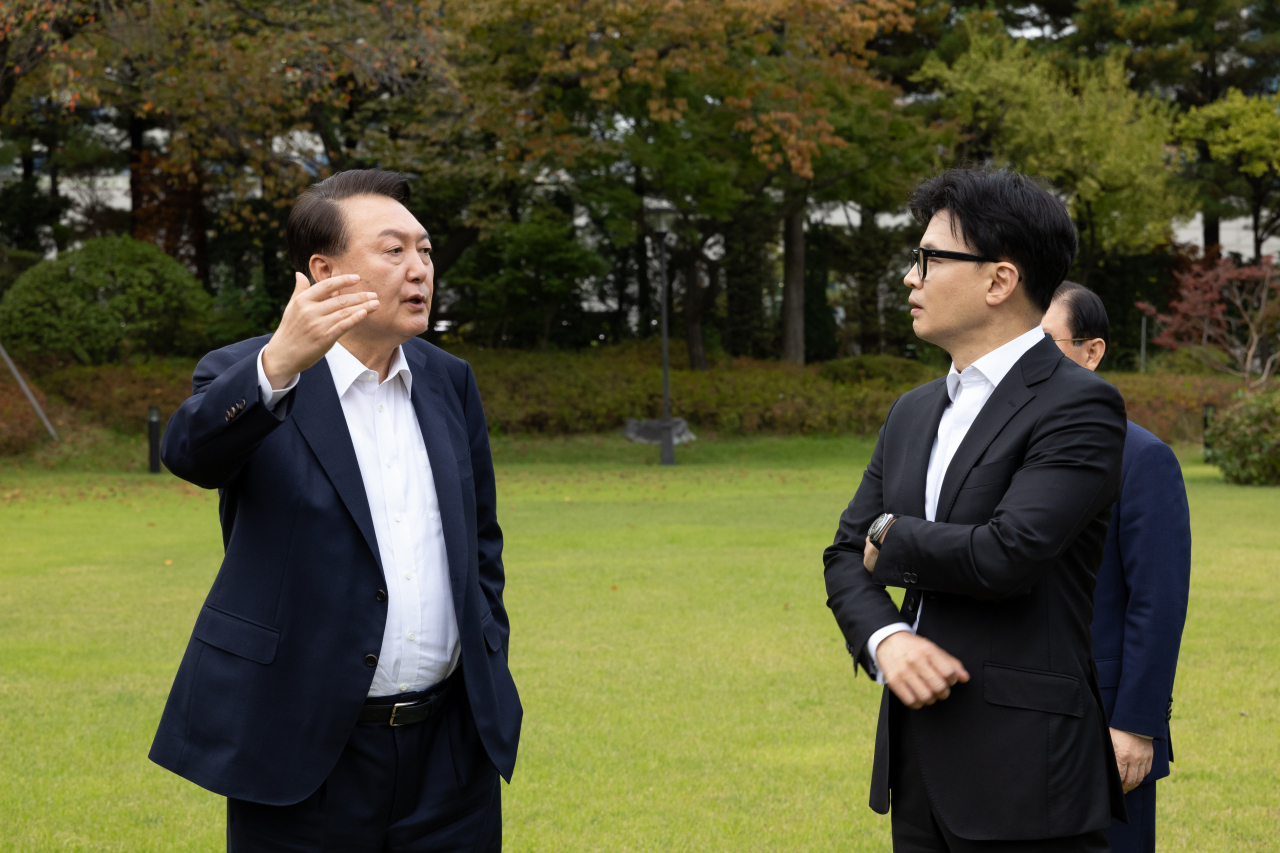 윤석열 대통령이 21일 서울 용산 대통령실 파인그라스 앞 잔디마당에서 국민의힘 한동훈 대표를 만나 대화하고 있다. [연합]