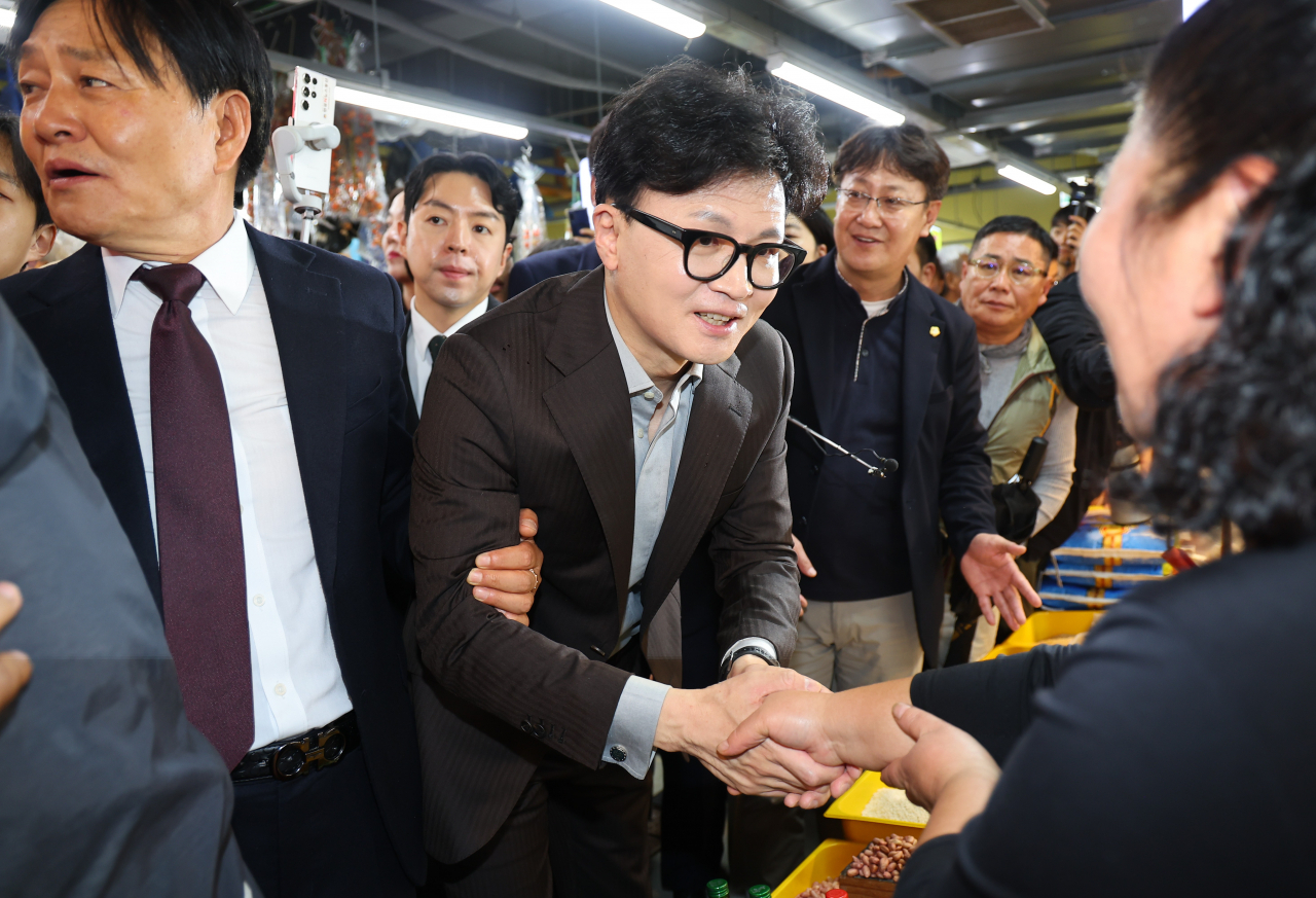 한동훈 국민의힘 대표가 22일 오후 인천 강화군 강화풍물시장을 방문, 10·16 재보궐선거에서 당선된 박용철 강화군수와 함께 상인들에게 당선 감사 인사를 하고 있다. [연합]