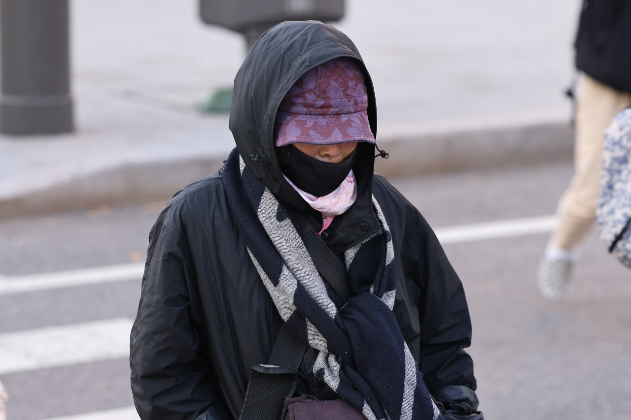 서울 아침 최저기온이 7도까지 떨어지며 추운 날씨를 보인 24일 오전 서울 종로구 광화문네거리에서 외투 모자를 쓰고 목도리를 한 시민이 이동하고 있다. [연합]